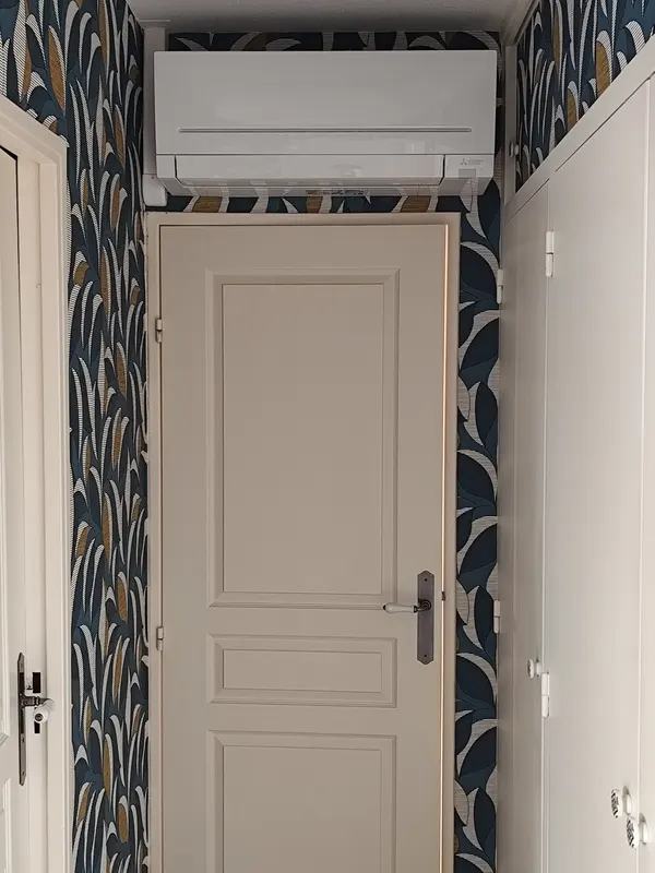 Unité intérieure de climatisation réversible au-dessus d'une porte, maison à Saint-Apollinaire