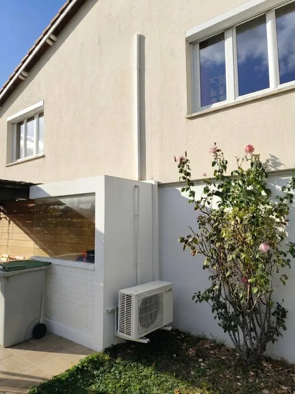 Groupe extérieur de pompe à chaleur air-air fixé au mur d'une maison à Saint-Apollinaire